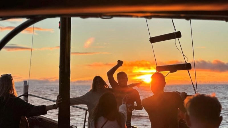 a group of people standing next to a body of water